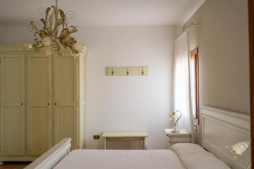 a bedroom with a bed and a chandelier at Ghisolana Agriturismo al Capitello in Asolo