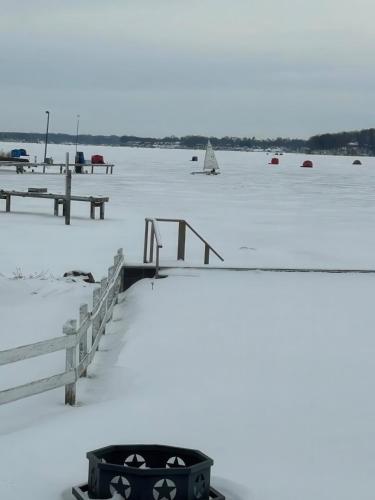 a snow covered pier with a boat in the water at Waterfront Sodus Gem, Dock Game Loft Bay View in Sodus Point