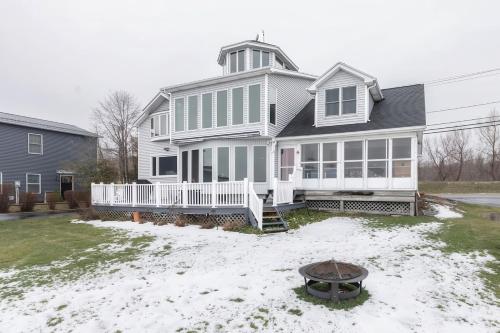 a large white house with snow on the yard at Waterfront Sodus Gem, Dock Game Loft Bay View in Sodus Point