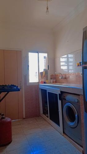 a kitchen with a washing machine and a sink at Hind Hanouda in Kenitra