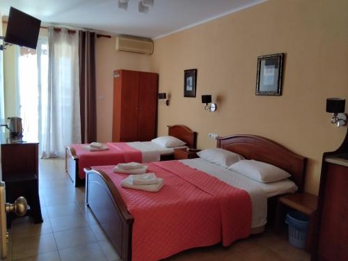 a hotel room with two beds with red sheets at Olympic Studios Aslanidis in Olympic Beach