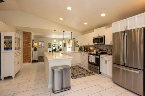 a large kitchen with white cabinets and stainless steel appliances at East Bench Bungalow A Relaxing Ogden Escape Near Mountains and Downtown in Ogden