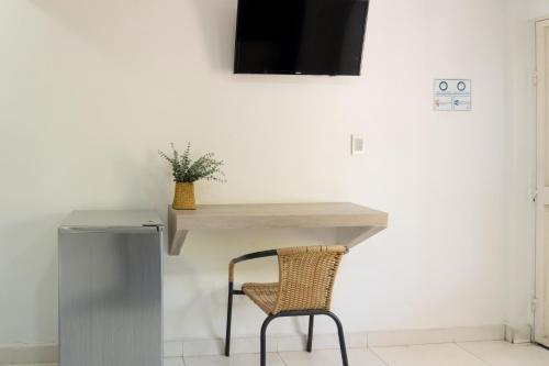 a desk with a chair and a television on a wall at Hotel Bello Caribe Rodadero in Santa Marta