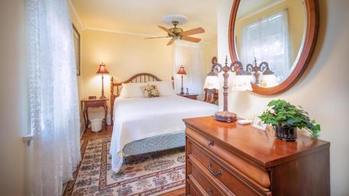 - une chambre avec un lit, un miroir et une commode dans l'établissement Lillys Butterscotch Cottage-5 Bdrm Wbonus Loft!!, à Cape May