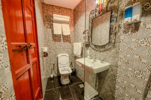 a bathroom with a sink and a toilet and a mirror at Riad Diamant De Fes in Fès