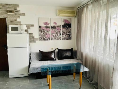 Un dormitorio con una cama con una mesa y un microondas. en Bravo 1, en Sunny Beach