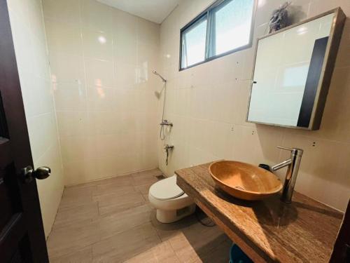 a bathroom with a wooden sink and a toilet at Exclusive Bungalow Private & Peaceful in Miri Ocean Park 5BR in Miri