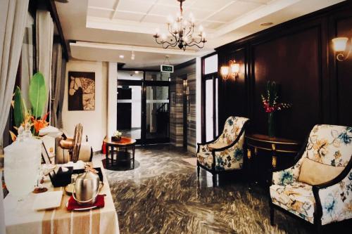 a lobby with two chairs and a table and a chandelier at Happy Life Memories Hoi An Hotel & Spa in Hoi An