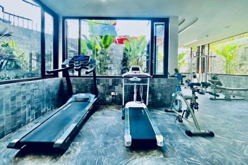 a gym with two treadmills and a swimming pool at Happy Life Memories Hoi An Hotel & Spa in Hoi An