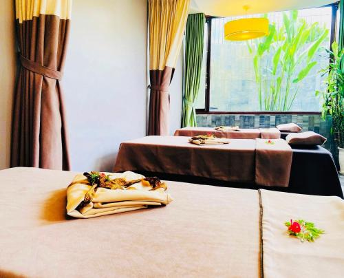 a room with two beds and a window at Happy Life Memories Hoi An Hotel & Spa in Hoi An