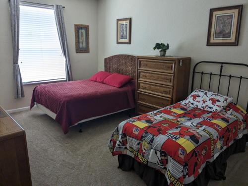 a bedroom with two beds and a dresser at Water Park & Fantastic Pool only Minutes To Walt Disney World's Front Gate!!! in Orlando