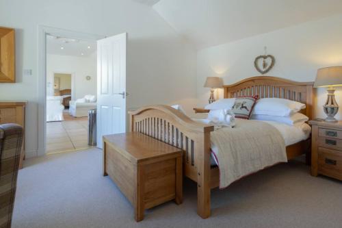 ein Schlafzimmer mit einem großen Bett mit einem hölzernen Kopfteil in der Unterkunft Oak Cottage and Hot Tub, Loch Tay in Lawers