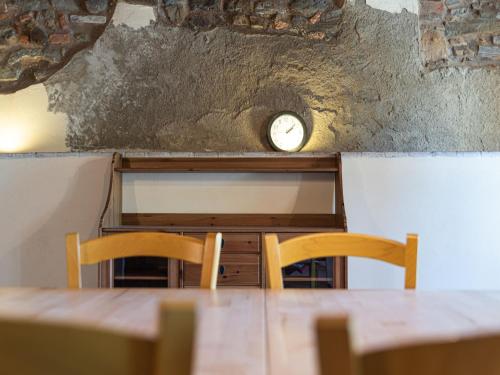 a table with two chairs and a clock on the wall at Holiday Home in Ca' De' Grimaldi with Garden in Castellarano