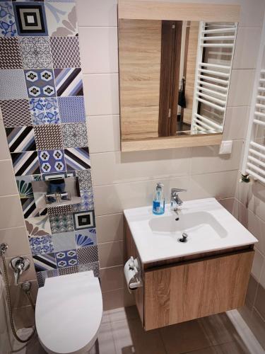a bathroom with a sink and a toilet and a mirror at Style chic et calme a la Marsa, emplacement Ideal in Dar el Haj Ahmed Souid