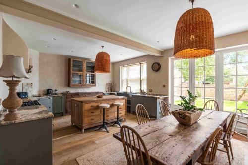 a large kitchen with a wooden table and chairs at Sanctuary House with Parking By My Getaways in Shoreham-by-Sea