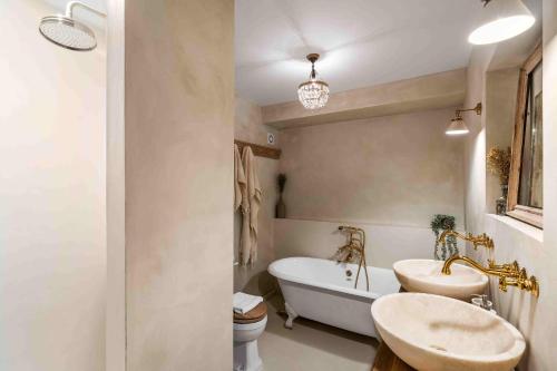 a bathroom with a sink and a tub and a toilet at Sanctuary House with Parking By My Getaways in Shoreham-by-Sea