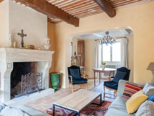 a living room with a fireplace and a table at Villa in Saignon with Pool and Scenic Views in Ménerbes