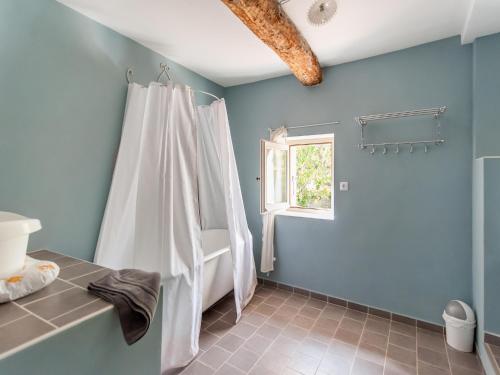 a bathroom with a white shower curtain and a window at Villa in Saignon with Pool and Scenic Views in Ménerbes
