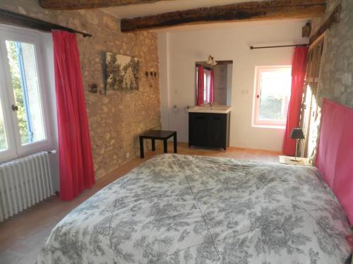 a bedroom with a large bed with red curtains at Villa in Saignon with Pool and Scenic Views in Ménerbes