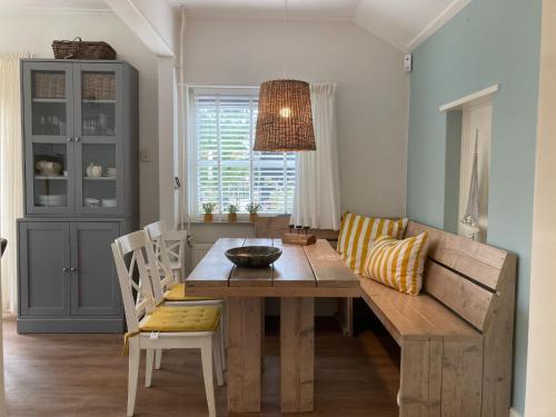 a dining room with a wooden table and chairs at Beautiful holiday home Zeeroos in Zeeland in Dishoek