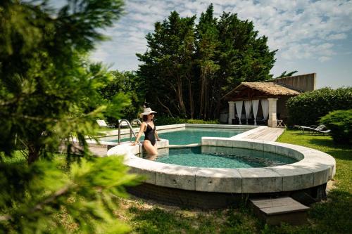 a woman in a hat standing next to a swimming pool at Justin de Provence in Orange