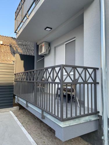 ソンボルにあるApartman Bellaの家の上に木製の手すり付きのバルコニー