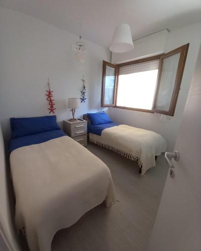 a bedroom with two beds and a window at La Casa del Sole in Follonica
