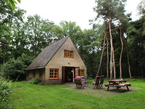 a small house with a table and chairs in a yard at Holiday Home in De Wolden near Forest in Zuidwolde