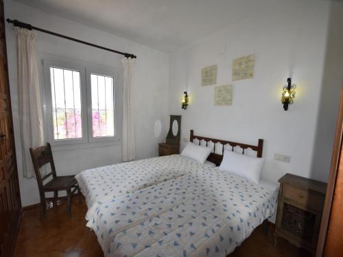 a white bedroom with a bed and a window at Coastal Villa Near Beaches in Moraira