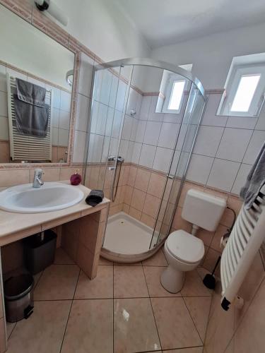 a bathroom with a sink and a toilet and a shower at Velvet Motel in Hegyeshalom