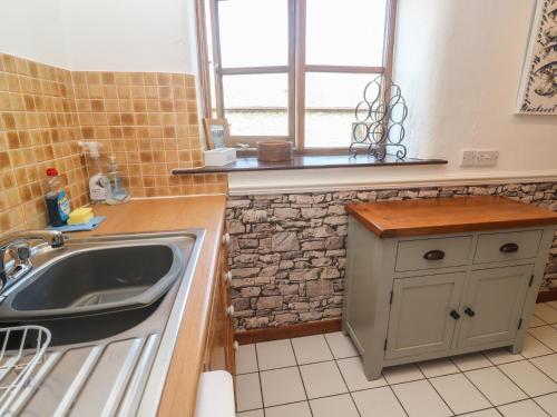 ペンザンスにあるMill House Barnのシンクと窓のあるキッチン