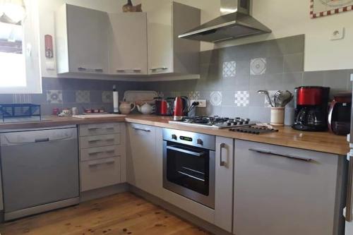 a kitchen with white cabinets and a stove top oven at Chalet in Raon-l'Étape near Lake in Raon-lʼÉtape