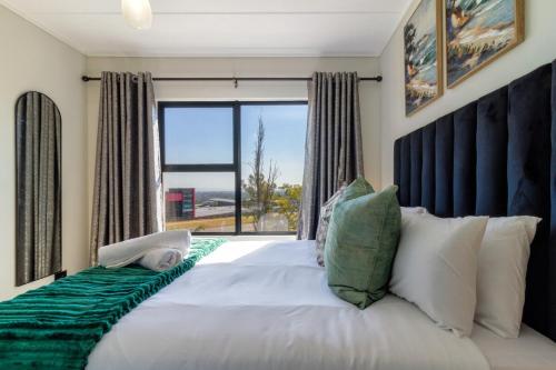 a bedroom with a large bed with a large window at AlimamaSpaces Panos Whisken in Midrand