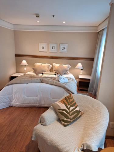 a bedroom with a large bed with pillows on it at Conforto Flat Hotel Vila Olimpia in São Paulo