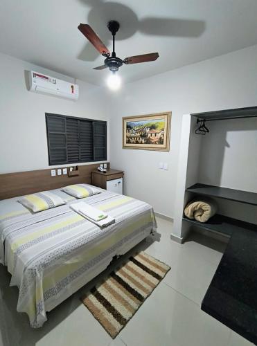 a bedroom with a bed and a ceiling fan at Hotel Graunas in São Carlos