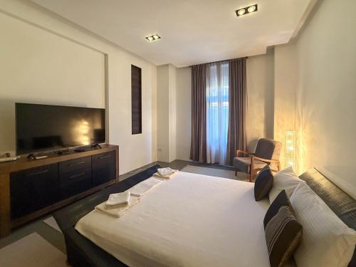 a bedroom with a large bed and a flat screen tv at City Center Apartment in Belgrade