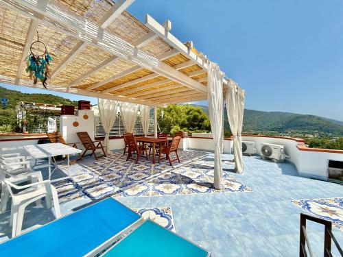 a patio with a table and chairs under a pergola at La Maison de Annabella in Palinuro