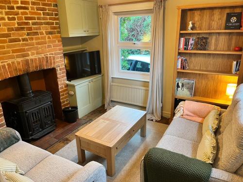 a living room with a couch and a fireplace at Charming countryside cottage in Bekesbourne