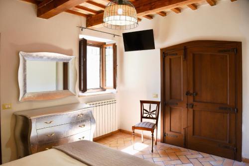a bedroom with a bed and a tv and a chair at Genga Terme Retreat - 1 BR Apt with garden in Genga