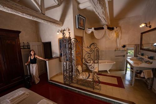 a woman standing next to a gate in a bathroom at Justin de Provence in Orange