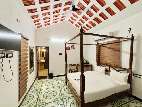 a bedroom with a four poster bed in a room at Courtyard Castle Heritage Resort - Private Villa & Rooms in Pondicherry