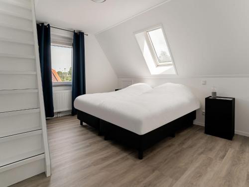 a bedroom with a white bed and a window at Group House in Lemele near Heuvelrug in Lemele