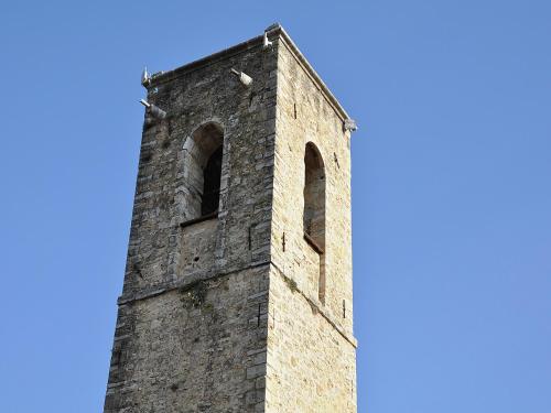 a tall brick tower with windows on a blue sky at Village House in Fayence with Castle Views in Fayence