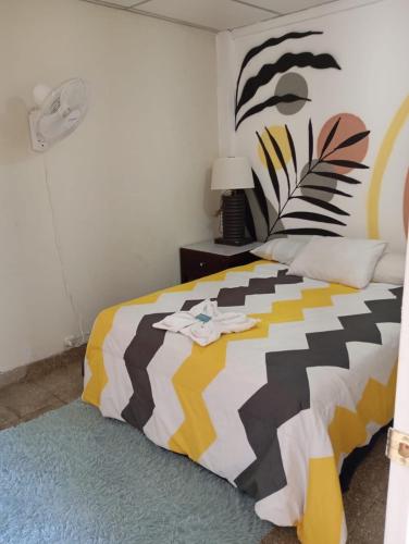 a bedroom with a bed with a colorful comforter at Napoli Centro in Santa Ana