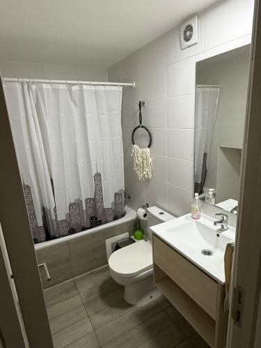 a white bathroom with a toilet and a sink at Departamento centro 2D 2B in Concepción