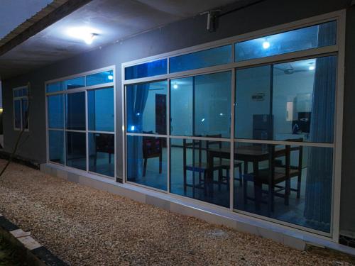a room with a dining table and windows at night at Beachfront Bliss Zanzibar - Stylish 1BR Oceanview Apartment in Uroa in Uroa