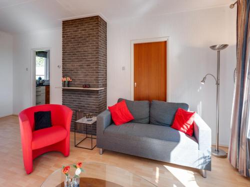 a living room with a couch and a red chair at Holiday Home Mantinge near Nature Reserve in Mantinge