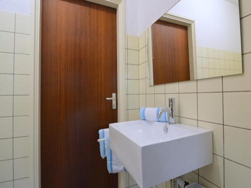 a bathroom with a white sink and a mirror at Holiday Home Mantinge near Nature Reserve in Mantinge