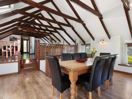 a dining room with a wooden table and black chairs at Ysgubor Uchaf in Whitland