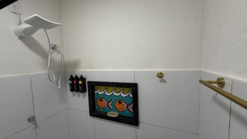 a painting in a corner of a bathroom with a light at Casa nova e aconchegante em condomínio in Petrolina